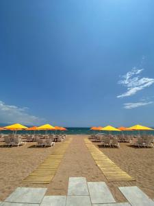 美西尼Buka Sandy Beach的海滩上的一排椅子和遮阳伞