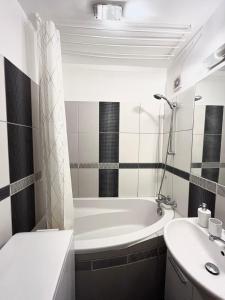 布拉迪斯拉发Elegant Escape apartment - free parking, easy access to City Centre的带浴缸和盥洗盆的浴室