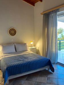 SkálaLuxury Beach Villa的一间卧室设有一张床和一个大窗户