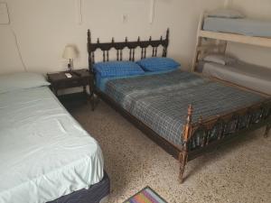 圣达菲Hotel Hostal Caballito Blanco的一间卧室配有两张单人床,床头柜配有床架