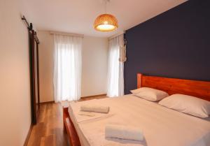 乌雷基Cottages in Kaprovani "Family nest"的一间卧室配有一张白色大床和蓝色的墙壁