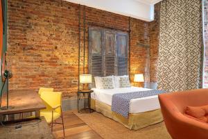 里约热内卢Selina Lapa Rio de Janeiro的一间卧室设有一张床和砖墙
