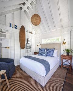肯纳邦克Wanderer Cottages的一间卧室配有一张大床和一把椅子