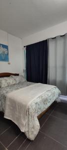 科阿特佩克La puerta azul的一间卧室配有一张床铺,床上有毯子
