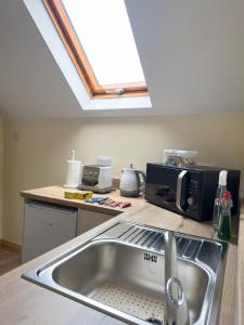 巴利卡斯尔Clare Forest Apartment的厨房设有水槽和天窗。