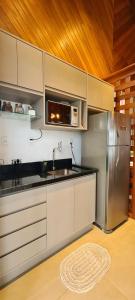 新彼得罗波利斯Josef’s Chalé的厨房配有不锈钢冰箱和微波炉。