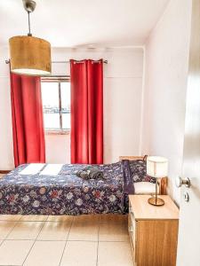 ArrentelaGolden Place - Seixal的一间卧室配有红色窗帘、一张床和窗户