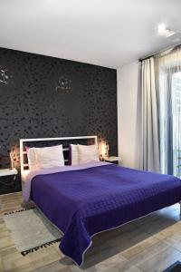 赫维兹Water Lily Boutique B&B and Bungalow的一间卧室配有一张带黑色墙壁的紫色床