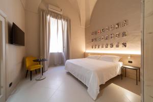 加利波利Palazzo Vergine - by Inside Salento的卧室配有白色的床和黄色椅子