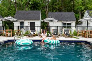 肯纳邦克Wanderer Cottages的坐在游泳池充气器上的女人和姑娘