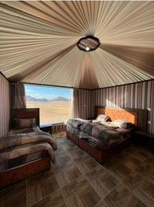 DisahEnjoy Wadi Rum stars的一间卧室设有两张床和大窗户