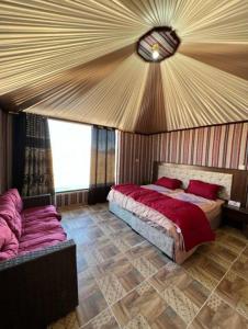 DisahEnjoy Wadi Rum stars的一间卧室配有一张床和一张沙发