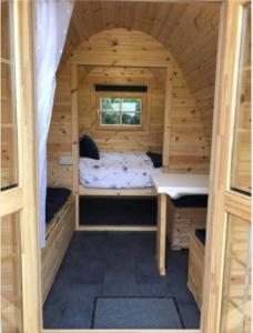 卡纳芬Pen y Buarth Pod - Caravan Site的小屋设有床和窗户。