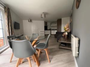 法恩伯勒Luxury Apartments - Wallis Square, Farnborough的用餐室以及带桌椅的起居室。