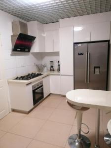 KgaphamadiCountry Block-Holiday home的白色的厨房配有不锈钢冰箱和桌子