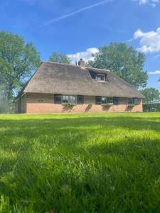 Den HamUnieke Twentse boerderij - 4 bedrooms & huge private garden的前面有草地的大砖房