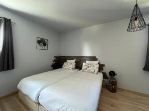 Pont-du-NavoyHôtel En Tilleul的卧室配有白色的床和2个枕头