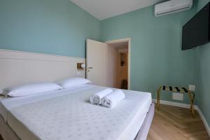 卡梅拉诺CAMERANOAPARTMENTS - L'ANGOLO DELLA PIAZZA的一间卧室配有一张床,上面有两条毛巾
