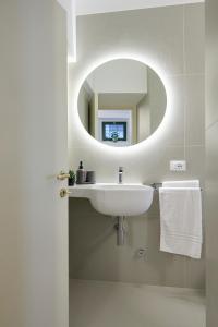 卡梅拉诺CAMERANOAPARTMENTS - L'ANGOLO DELLA PIAZZA的一间带水槽和镜子的浴室