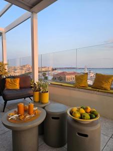 锡拉库扎LA TERRAZZA SUL PORTO的阳台配有水果桌,享有风景。