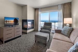 林肯市鹈鹕海岸酒店的客厅配有电视、沙发和椅子