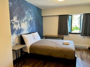 温哥华HI Vancouver Downtown - Hostel的一间卧室设有一张床和蓝色的墙壁