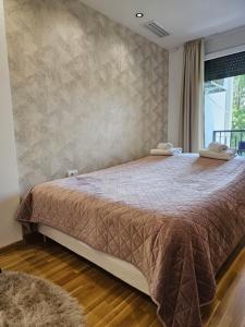 弗尔尼亚奇卡矿泉镇Mimi的一间卧室配有一张带棕色棉被的大床