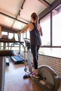 亚松森拉斯洛马斯卡萨酒店的站在健身房跑步机上的女人