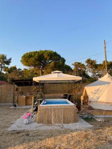 扎达尔Estera Tent Camping的一个带遮阳伞和帐篷的游泳池