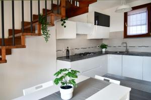 PioltelloNew LOFT free WI-FI & free parking [Milano-Linate]的一间厨房,配有白色橱柜和楼梯
