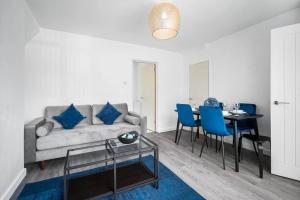 Bushbury3 bed house/Free parking/contractors/Families的客厅配有沙发和带蓝色椅子的桌子