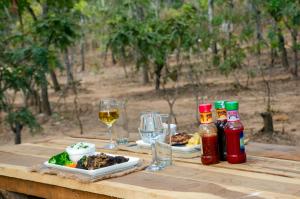 卢萨卡Nsunge Nsunge Farm and Natural Resort的木桌,带食物和酒盘
