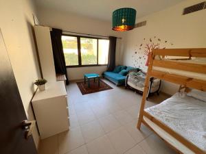 索瓦马Apartment at Samarah Dead Sea Resort的客房设有双层床和沙发。