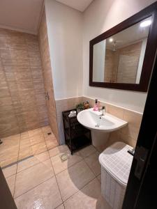 索瓦马Apartment at Samarah Dead Sea Resort的浴室配有盥洗盆和带镜子的淋浴