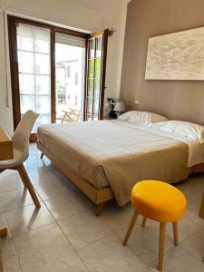 利多迪卡马约雷CasaGiò - Villetta su due piani的一间卧室设有一张大床和一张黄色凳子