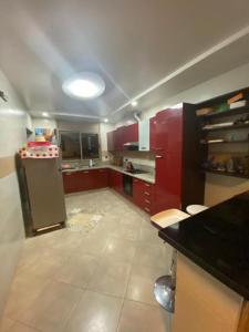 Ait Melloulأكادير ايت ملول的一个带红色橱柜和冰箱的大厨房