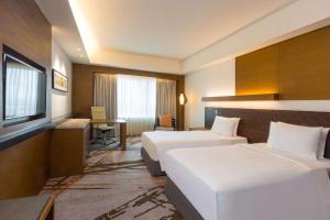宿务Radisson Blu Cebu的酒店客房配有两张床和一张书桌