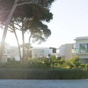 胡塞马Radisson Blu Resort Al Hoceima的享有部分树木和灌木丛的建筑景色