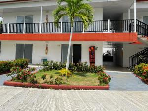 圣安德烈斯Hotel Mar de Corales By CAJASAI的庭院中种有棕榈树和鲜花的建筑