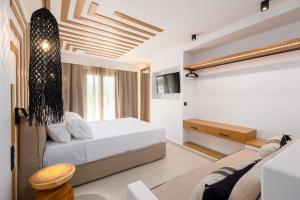 纳乌萨SunSal Luxury Studios - Sky的一间卧室配有一张床和一张沙发