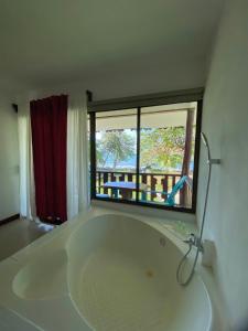 卡维塔Ocean View Lodge的窗户客房内的白色大浴缸