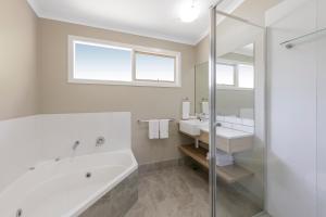 卡尔斯华美达菲利普岛度假酒店的白色的浴室设有浴缸和水槽。