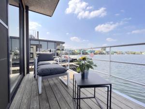MaasbommelJopies Houseboat的船上的阳台配有椅子和桌子