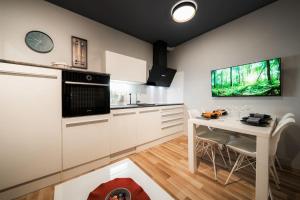 迪瓦查Cosy apartment的厨房配有白色橱柜和桌椅