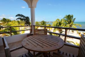 珀拉什奇亚Sandy Feet Beach Resort的海滩景阳台的木桌