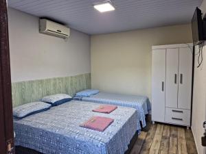 伊瓜苏Suite Cardoso的一间设有两张床的房间和一个橱柜