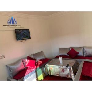 塔扎APPARTEMENT AL WAHDA的客房设有带枕头的沙发和桌子。