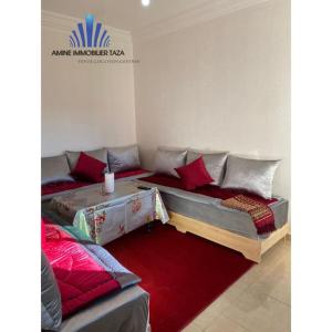 塔扎APPARTEMENT AL WAHDA的带沙发和红色地毯的客厅