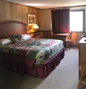 希利德纳利百乐酒店的卧室配有一张床和一张桌子及椅子