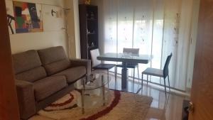 桑亨霍Apartamento Carabuxeira 1的客厅配有沙发和桌子